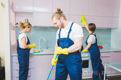 在工作过程中使用专业设备的清洁服务。专业的小厨房清洁, 沙发干洗, 窗户和地板清洗。穿制服、工作服和橡胶手套的男人和女人